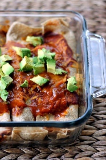 Incredible skinny huevos rancheros breakfast enchiladas rolled up with protein packed scrambled eggs, fresh veggies, and melty cheese, then baked in a delicious enchilada sauce. Perfect for breakfast meal prep or weekend brunch!