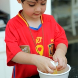 Young boy cracking an egg into a bowl
