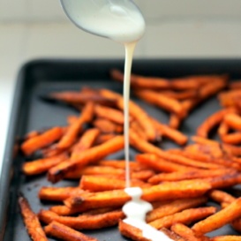 marshmallow glaze drizzling on to sweet potato fries on tray