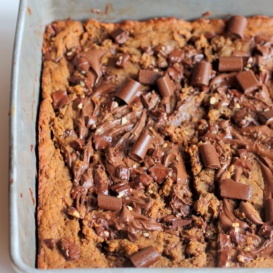 peanut butter blondies in pan with chocolate chunks on top