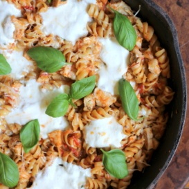 pasta with chicken, cheese, and basil in skillet