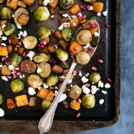 Roasted butternut squash and brussels sprouts with pomegranate and gorgonzola on a baking tray