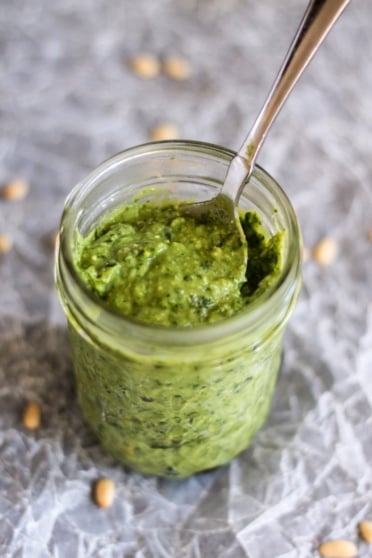 avocado basil pesto in a jar with a spoon