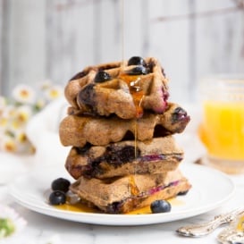 stack of paleo waffles with blueberries with maple syrup