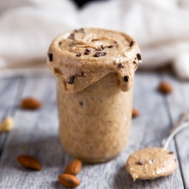 homemade cashew butter in a jar with cacao nibx