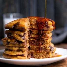 stack of whole wheat pumpkin chocolate chip pancakes with maple syrup
