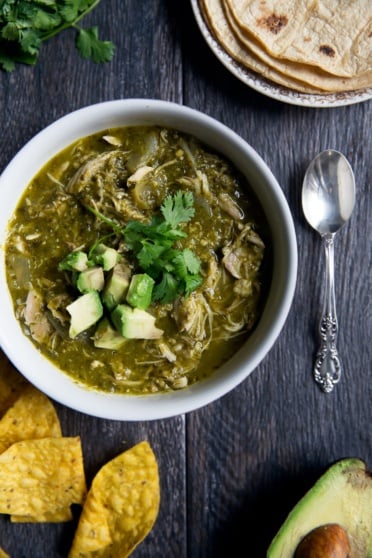 slow cooker chicken chile verde in a bowl topped with avocado