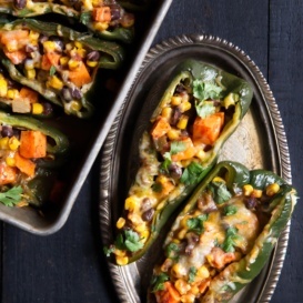 stuffed poblano peppers on a plate and on a baking tray