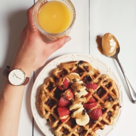 waffle on a plate with a side of orange juice