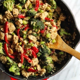 thai peanut chicken and edamame quinoa stir fry in a pan