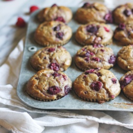 banana oatmeal muffins with raspberries in a muffin tin