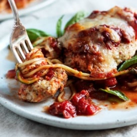 Baked Chicken Parmesan on a plate with zucchini noodles