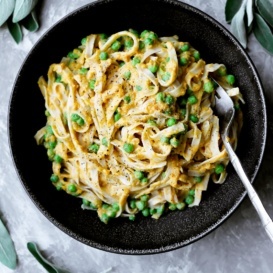 butternut squash pasta in a bowl with peas and a spoon