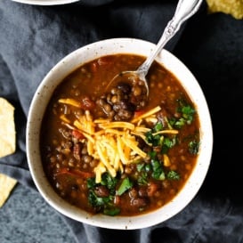 Slow Cooker Taco Lentil Soup in a bowl topped with cheese