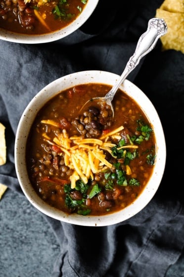 Slow Cooker Taco Lentil Soup in a bowl topped with cheese