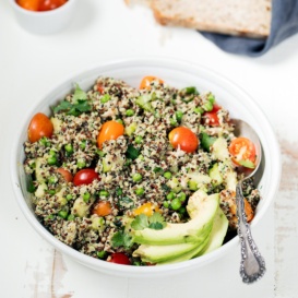 Tuna quinoa salad in a bowl with tomatoes and avocado