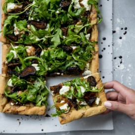 goat cheese pizza topped with arugula, goat cheese and figs