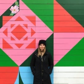 monique in front of a colorful wall