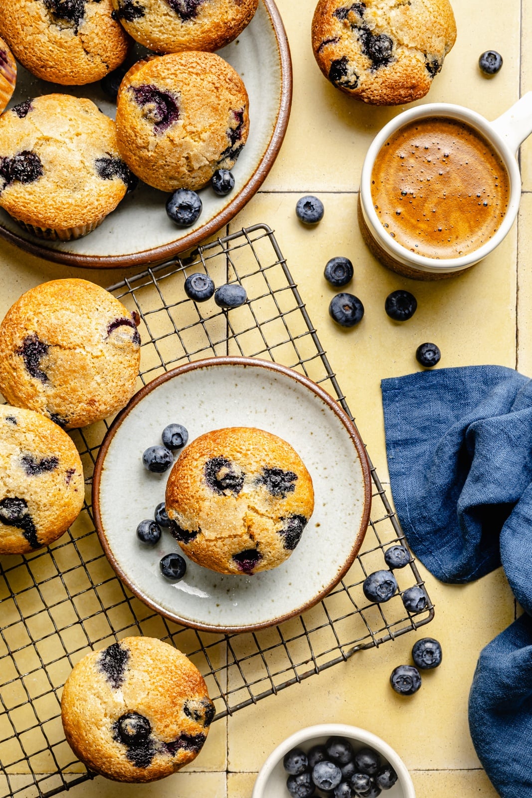 blueberry yogurt muffins on plates and a wire rack