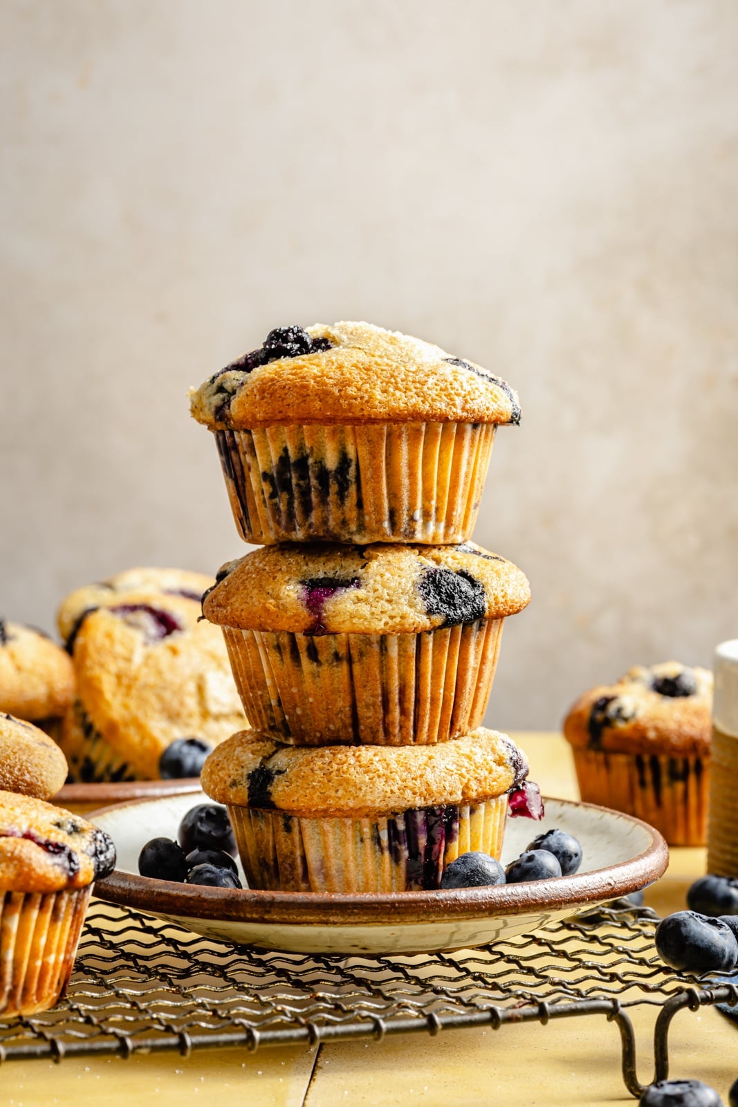 three blueberry yogurt muffins stacked on a plate