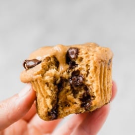 holding a sweet potato muffin with a bite taken out