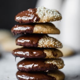 Brown butter tahini cookies dipped in chocolate in a stack