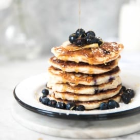 quinoa pancakes on a plate topped with blueberries