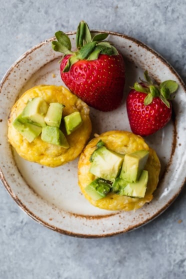 sausage egg and cheese muffins on a plate with strawberries