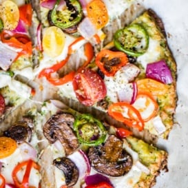 low carb zucchini pizza crust topped with cheese and veggies cut into slices