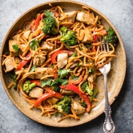 spicy thai peanut chicken stir fry on a plate with a fork