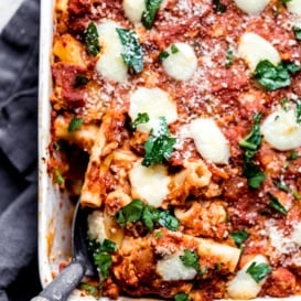 baked pumpkin pasta in a baking dish with a spoon