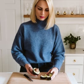 blonde woman demonstrating how to cut an avocado
