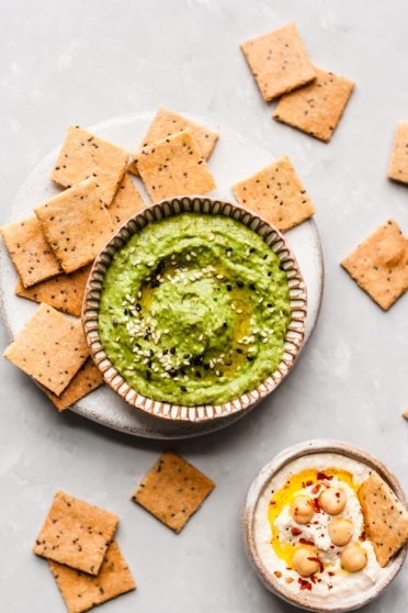 paleo crackers on a plate next to a bowl of guacamole