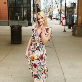 blonde woman on a sidewalk holding an ice cream cone