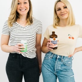 two girls standing with drinks in their hands