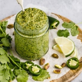 vegan cilantro pistachio pesto in a jar with a spoon
