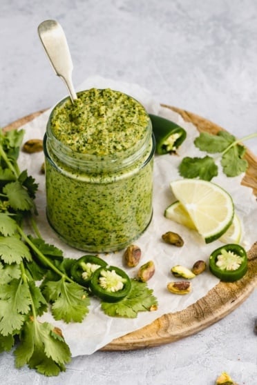 vegan cilantro pistachio pesto in a jar with a spoon