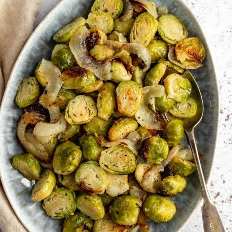 foil pack grilled brussels sprouts in a dish with a spoon