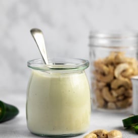 vegan cashew cream sauce in a jar with a spoon