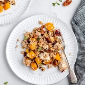wild rice casserole with butternut squash and chicken on a plate with a fork