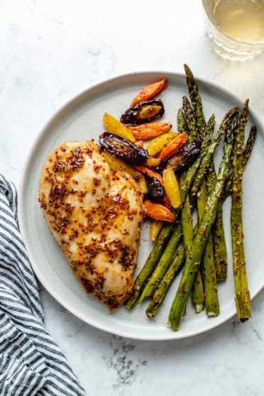 baked chicken breast on a plate with vegetables