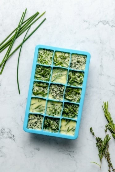 frozen herbs in a silicone ice cube tray