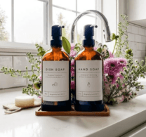 two glass soap dispensers next to flowers