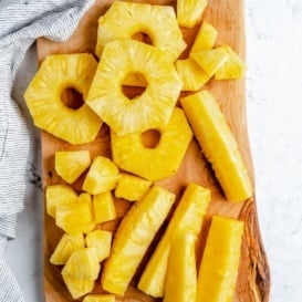 pineapple cut three different ways on a cutting board