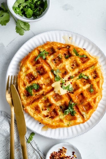 cheese and egg waffle on a plate with butter