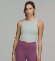 woman in a green tank top and purple leggings