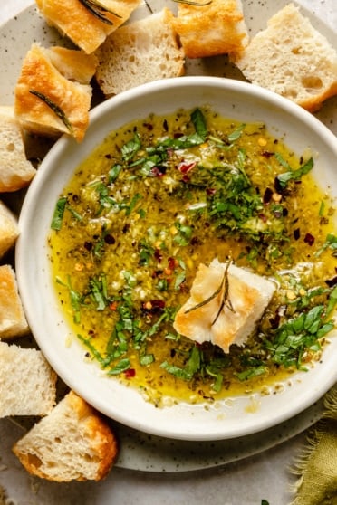 olive oil dip in a bowl with a piece of bread