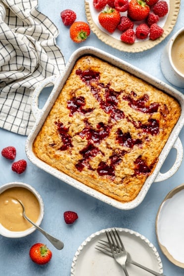 peanut butter and jelly oatmeal bake in a dish with toppings