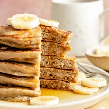 stack of banana oatmeal pancakes with a slice cut out