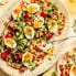 spiced chickpeas and eggs with cucumber salad and yogurt on a platter